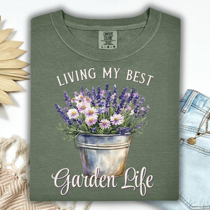 Moss green "Living My Best Garden Life" t-shirt with a lavender and daisy bucket graphic.