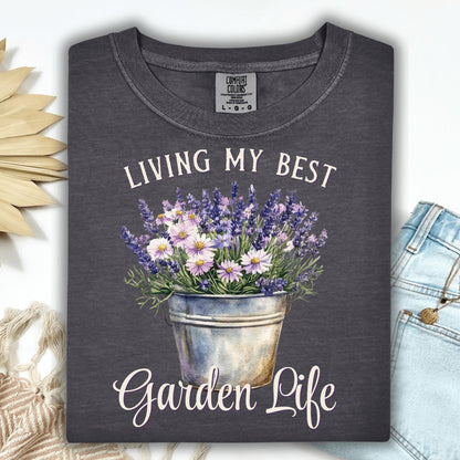 Pepper Comfort Colors t-shirt with "Living My Best Garden Life" text and a bucket of lavender and daisies.