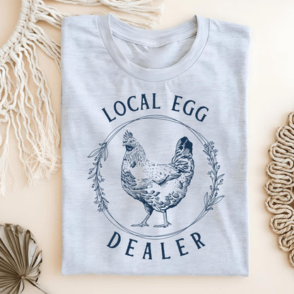 Ash S Local Egg Dealer t-shirt with a vintage hen and floral wreath design in navy blue.