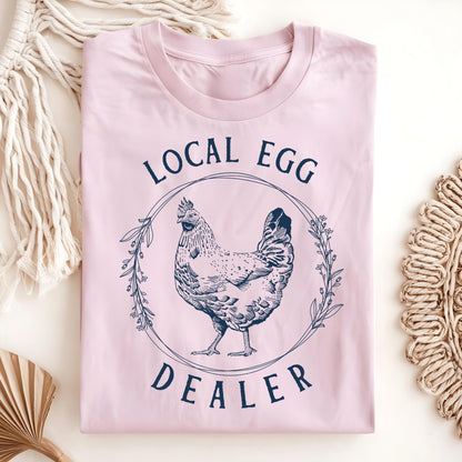 Light pink Local Egg Dealer T-shirt with a vintage hen and floral wreath design, size S, made of soft, thick cotton.