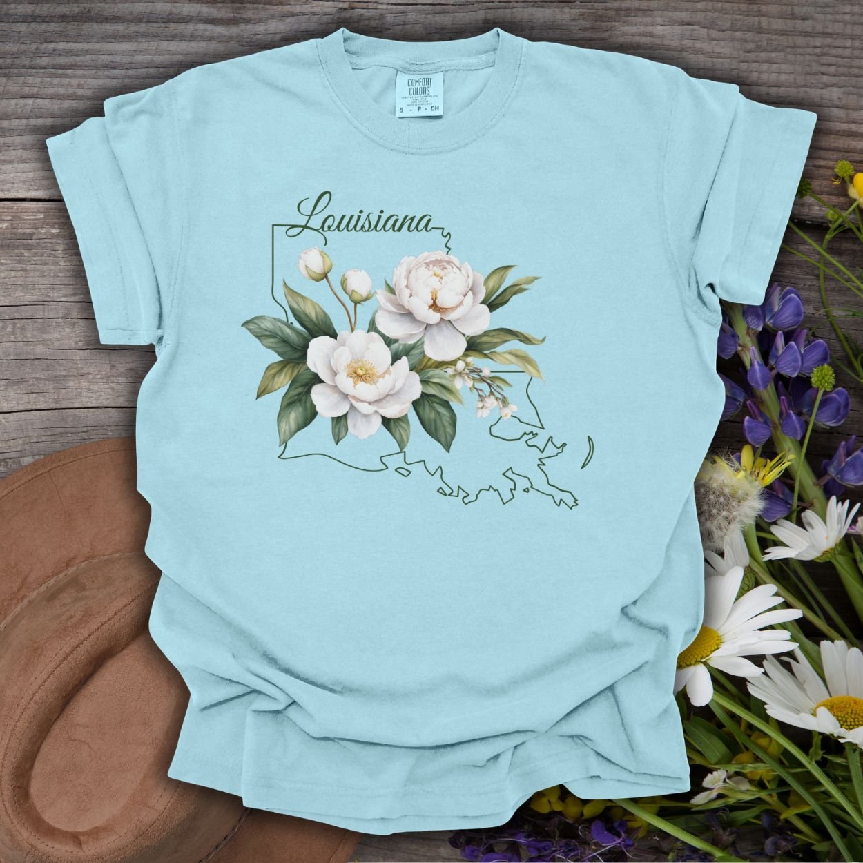 Chambray blue garment-dyed cotton t-shirt with a white magnolia and Louisiana outline graphic.