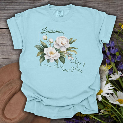 Chambray blue garment-dyed cotton t-shirt with a white magnolia and Louisiana outline graphic.