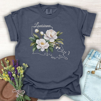 Denim blue garment-dyed cotton t-shirt with a white magnolia design over a Louisiana outline.