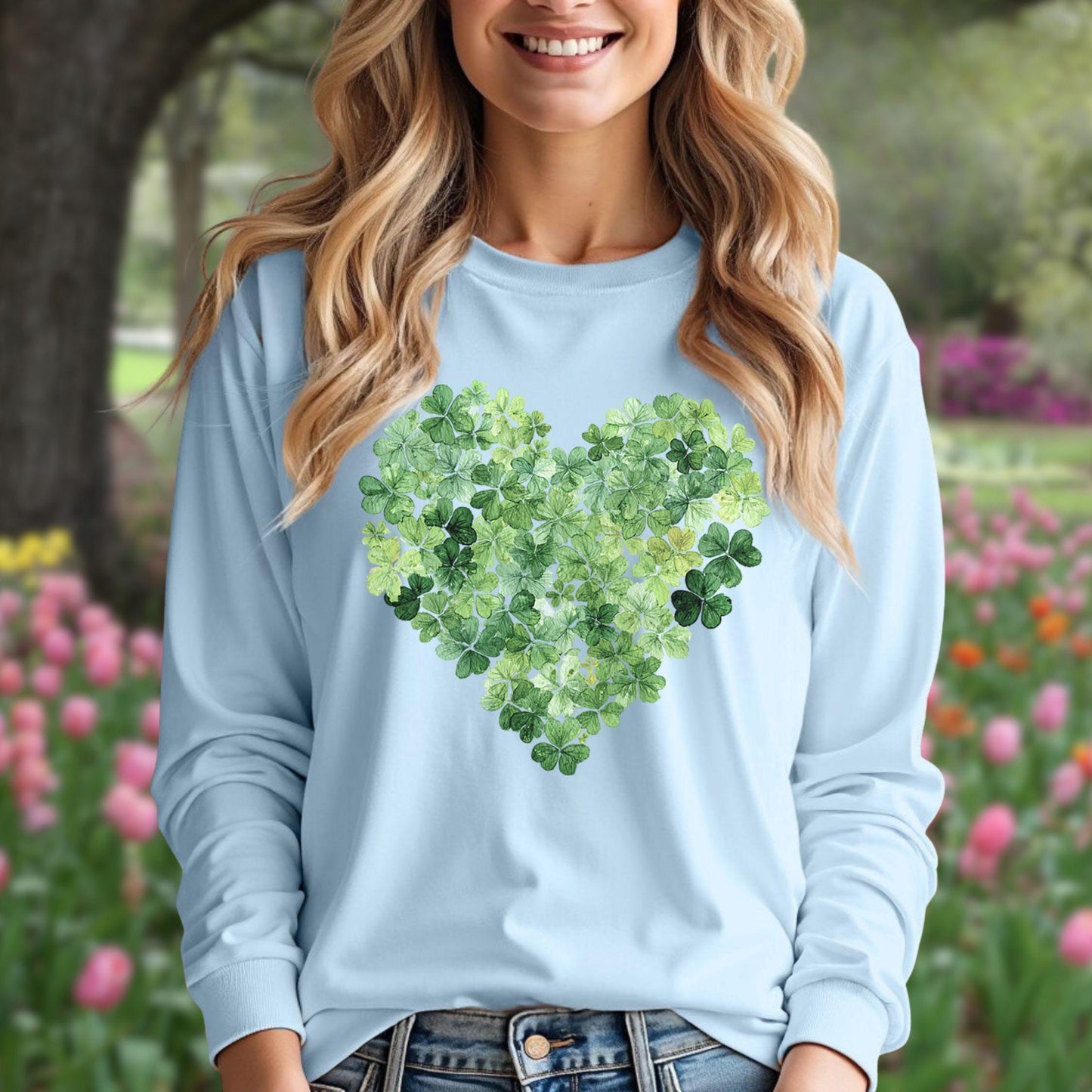 Woman in a light blue long-sleeve tee with a heart made of green clover leaves.