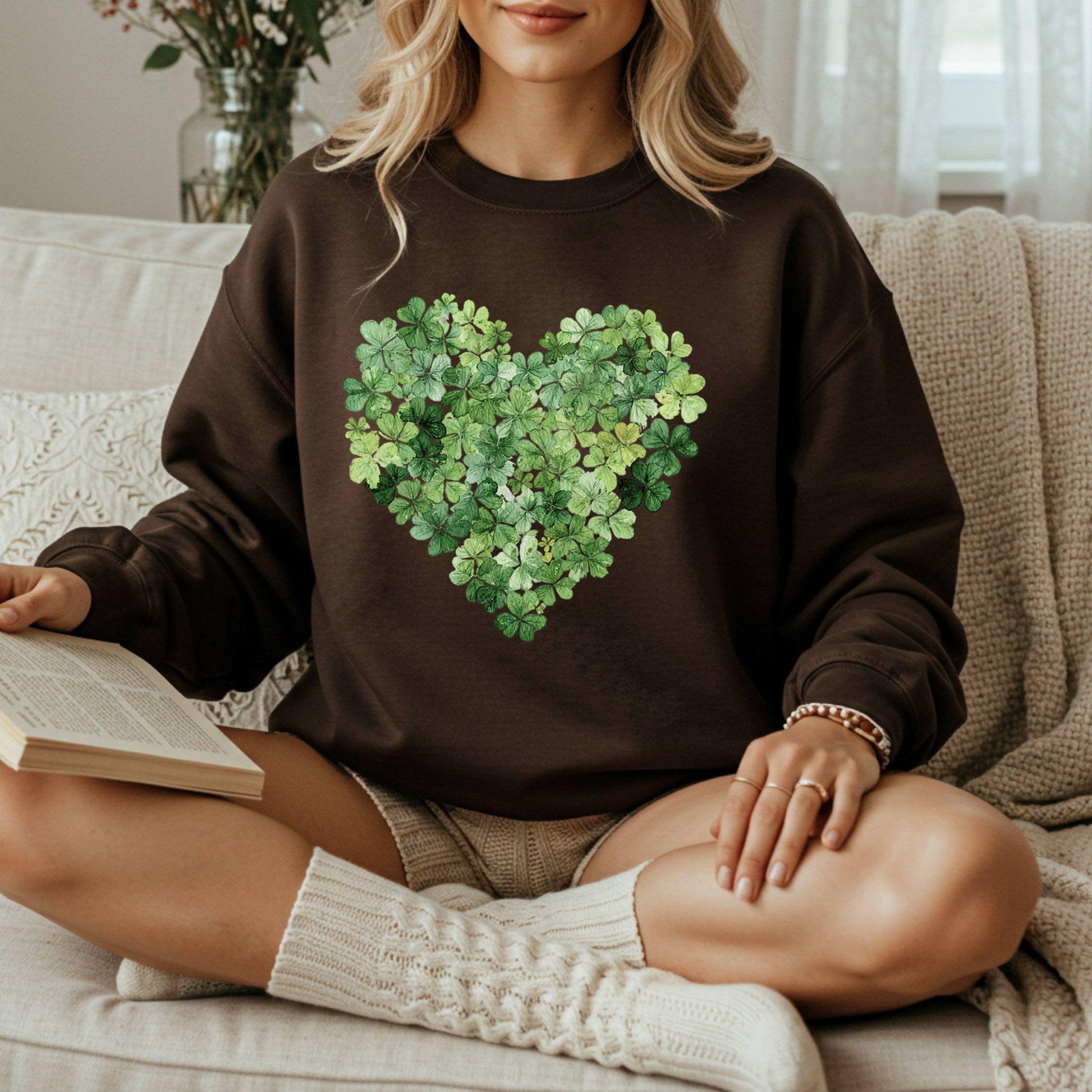 Brown sweatshirt with a heart-shaped design made of green four-leaf clovers.
