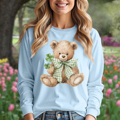 Watercolor teddy bear with checkered bow tie and four-leaf clovers on a light blue long-sleeve tee.