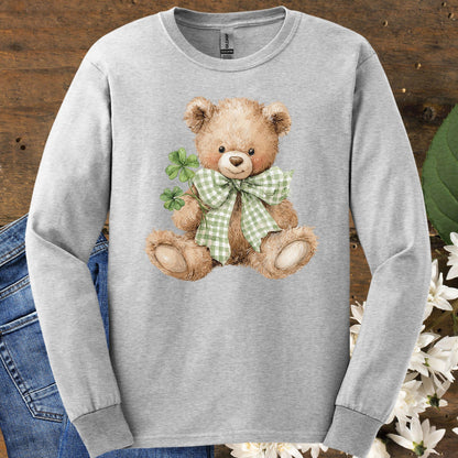 Ash long-sleeve tee with a watercolor teddy bear holding clovers and wearing a green checkered bow.