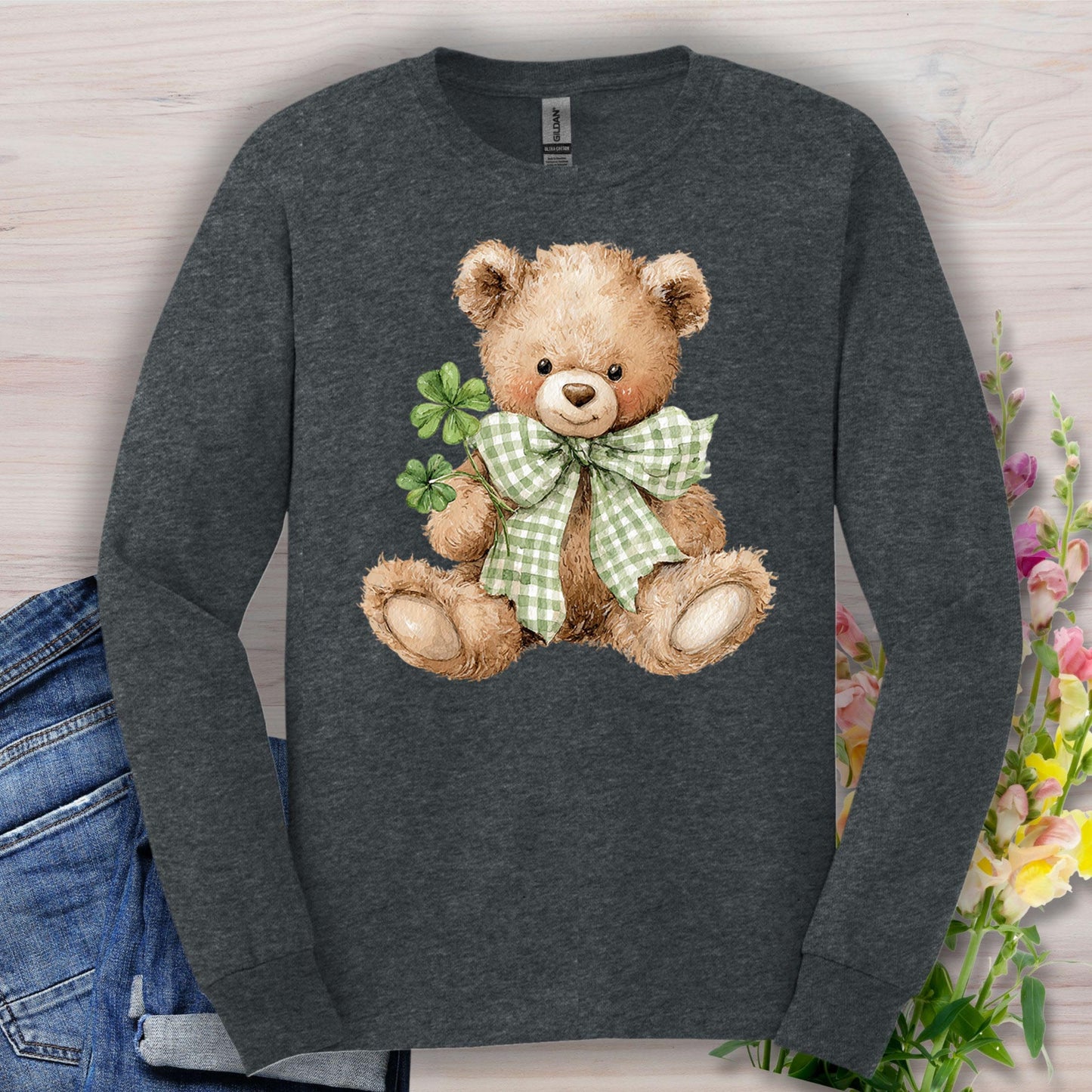 Dark Heather long-sleeve tee with a watercolor teddy bear holding clovers and wearing a checkered bow.