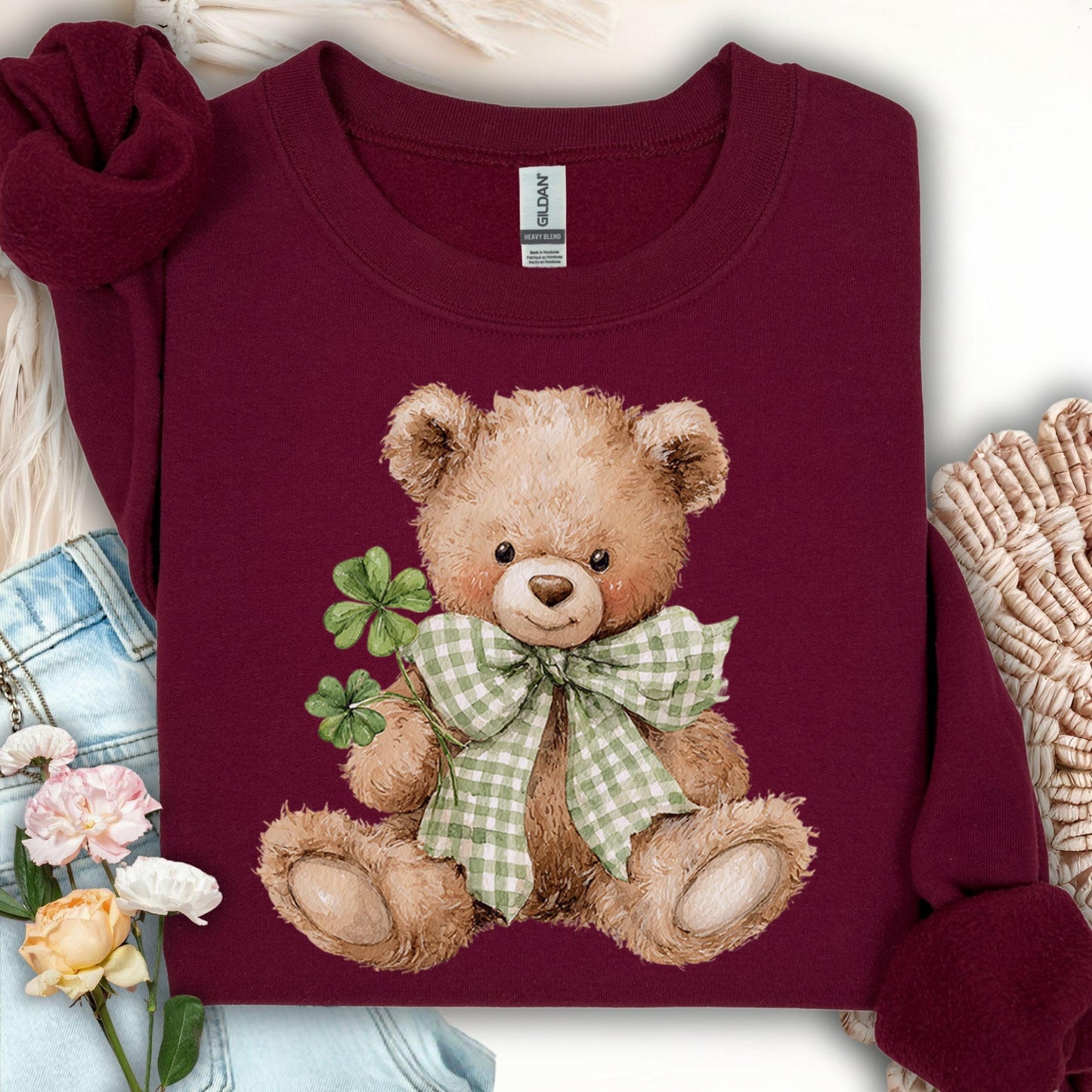 Maroon S sweatshirt with a watercolor teddy bear holding shamrocks and wearing a green plaid bow.