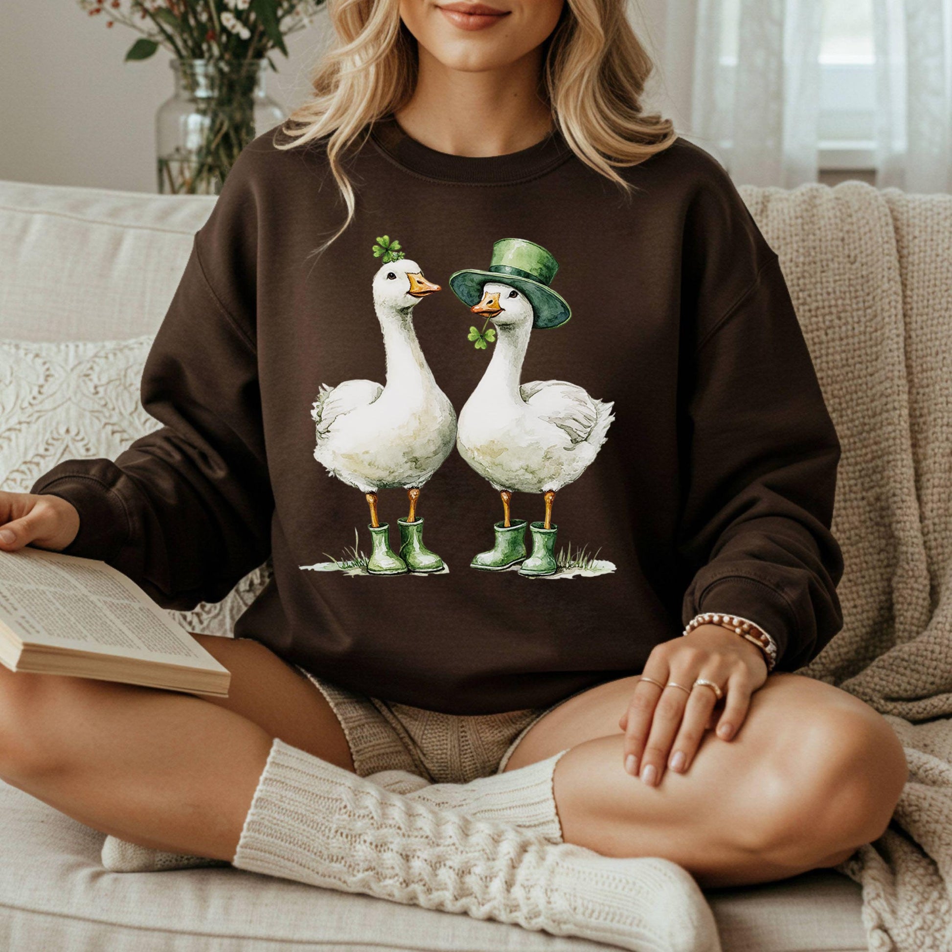 Brown sweatshirt with two St. Patrick's Day geese in green boots, one with a shamrock, one with a leprechaun hat.