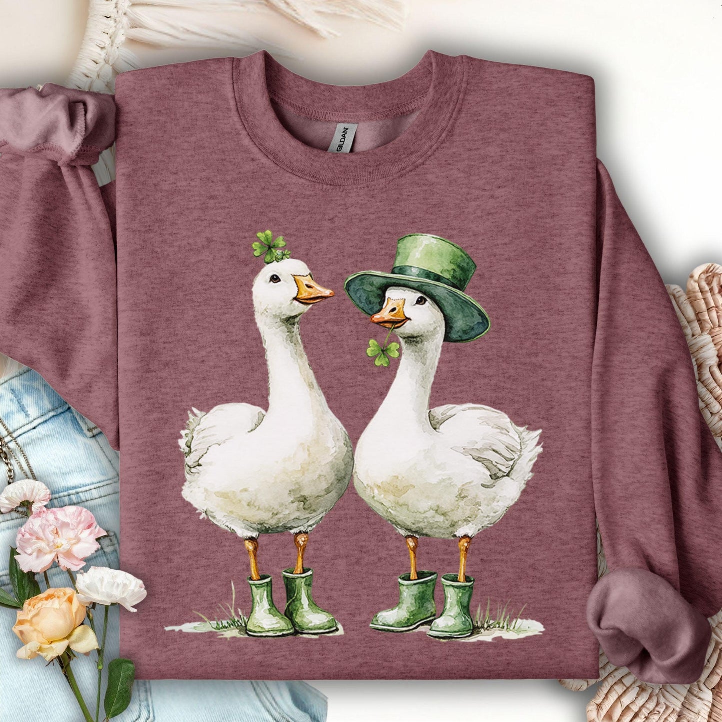 Heather Sport Dark Maroon sweatshirt with two geese in St. Patrick's Day attire, one with a shamrock, one with a leprechaun hat.