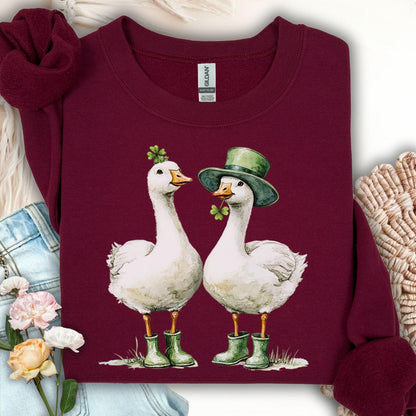 Maroon sweatshirt with two white geese in St. Patrick's Day attire, one with a shamrock, the other a leprechaun hat.