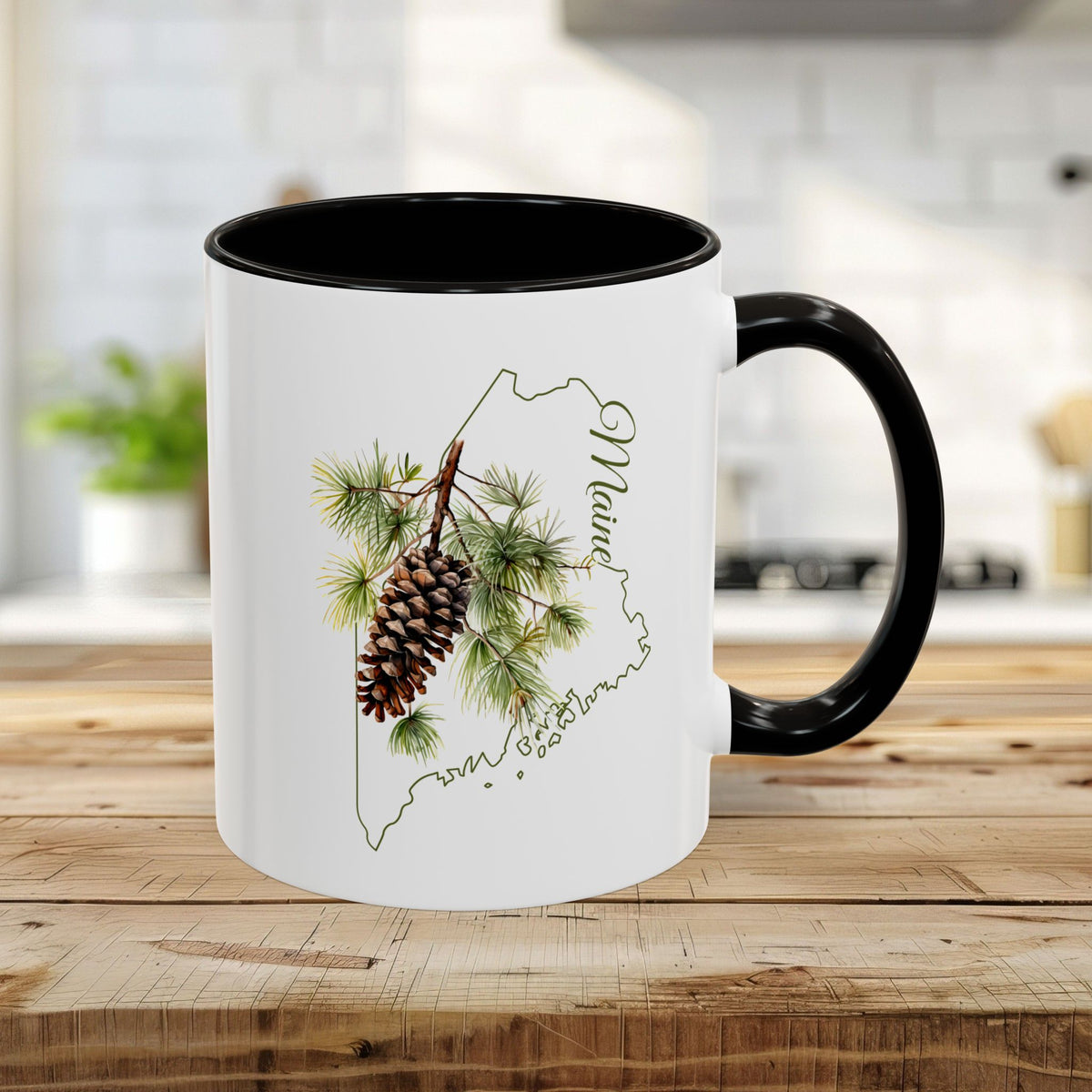 White 11oz ceramic mug with black interior/handle, featuring a watercolor pinecone and Maine state outline.