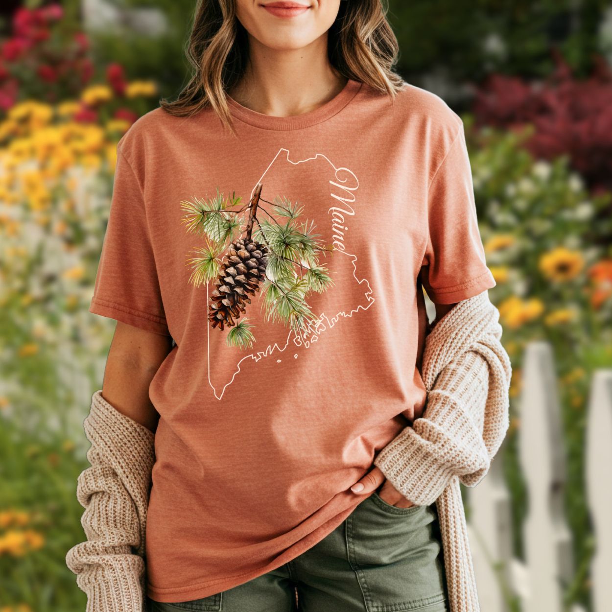 Relaxed-fit, garment-dyed t-shirt in faded terracotta with a Maine outline and pine cone design.