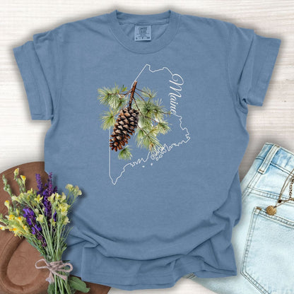 Blue Jean Maine State Flower T-Shirt with a pine cone and branch design over a map of Maine.