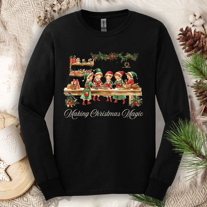 Black long sleeve tee with vintage Santa's workshop scene, elves, and "Making Christmas Magic" text.
