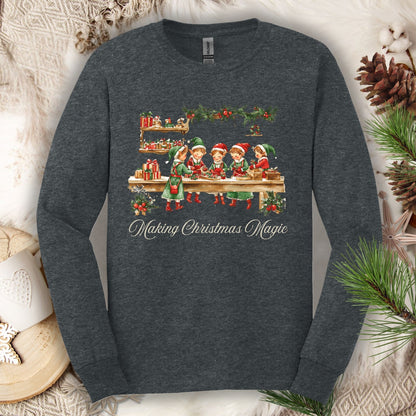 Dark Heather long sleeve tee with vintage Santa's workshop elves and "Making Christmas Magic" text.