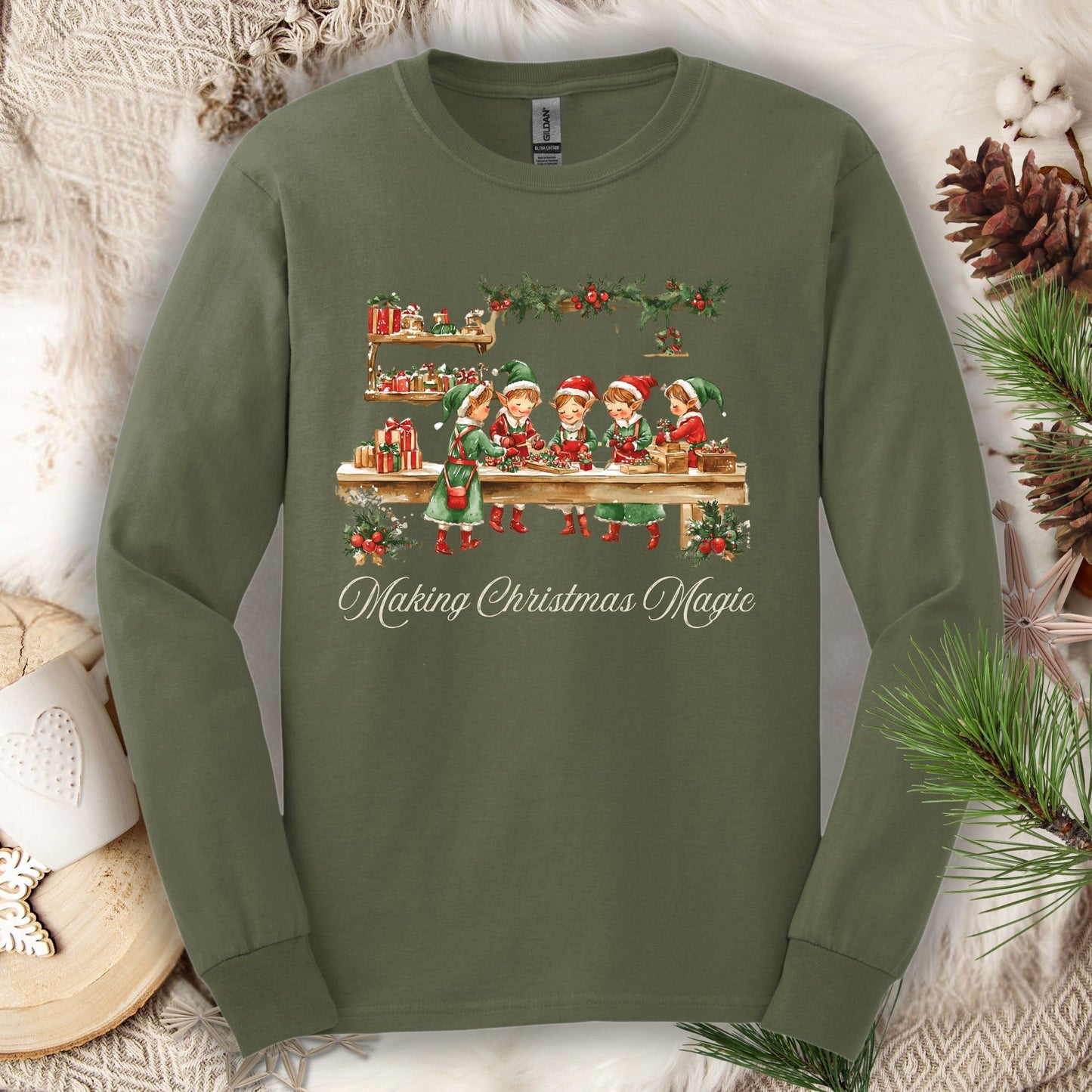 Military Green long sleeve tee with vintage Santa's workshop elves and "Making Christmas Magic" text.