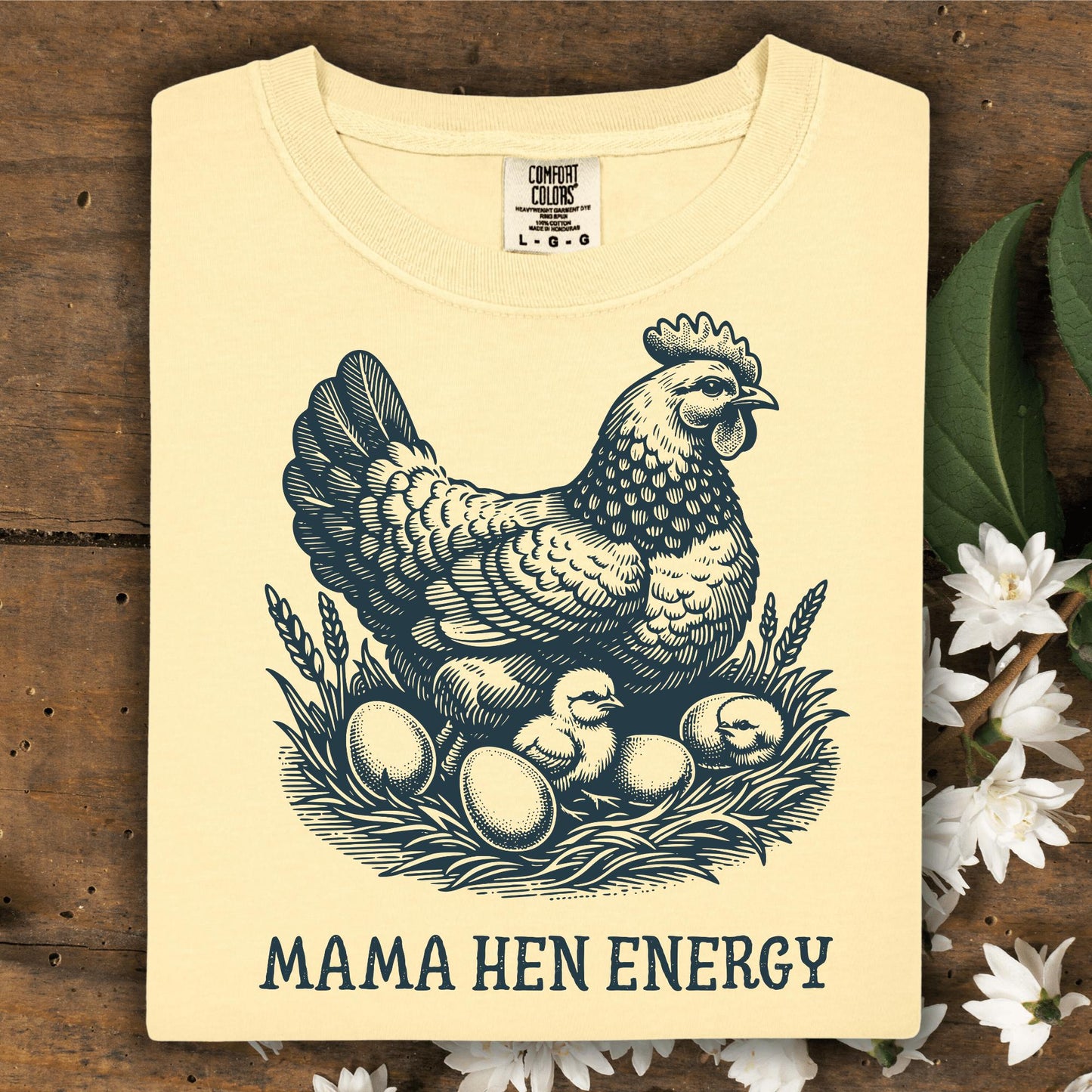 Butter yellow Comfort Colors tee with vintage hen, chicks, eggs, and "Mama Hen Energy" text.
