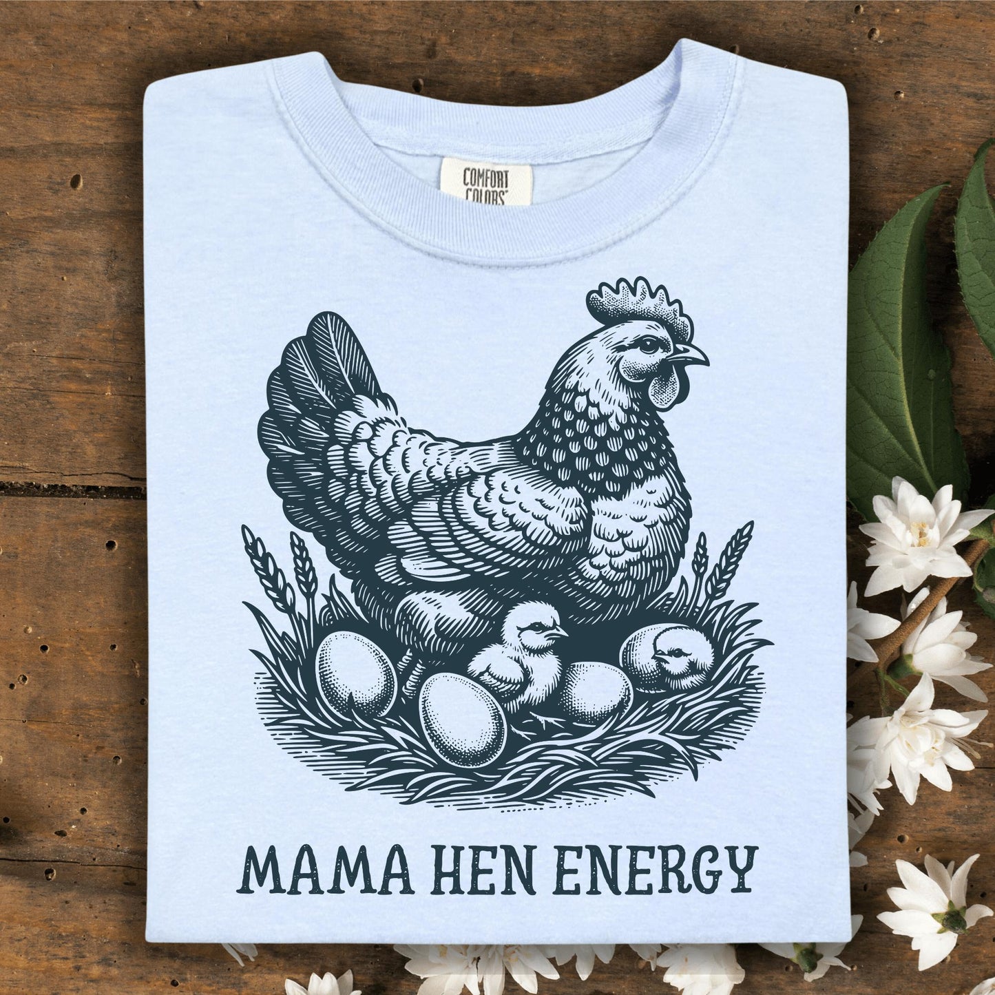 Hydrangea Comfort Colors t-shirt with a vintage hen, chicks, and eggs graphic, plus "MAMA HEN ENERGY" text.