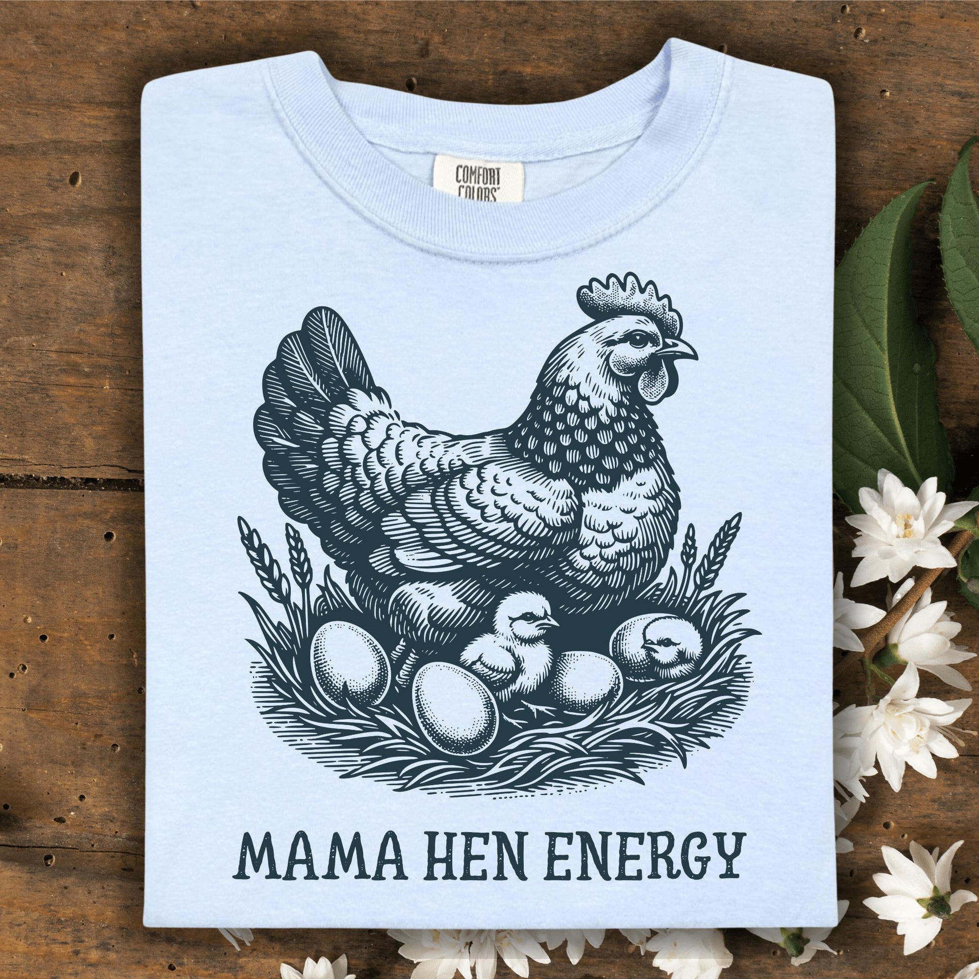 Hydrangea Comfort Colors t-shirt with a vintage hen, chicks, and eggs graphic, plus "MAMA HEN ENERGY" text.