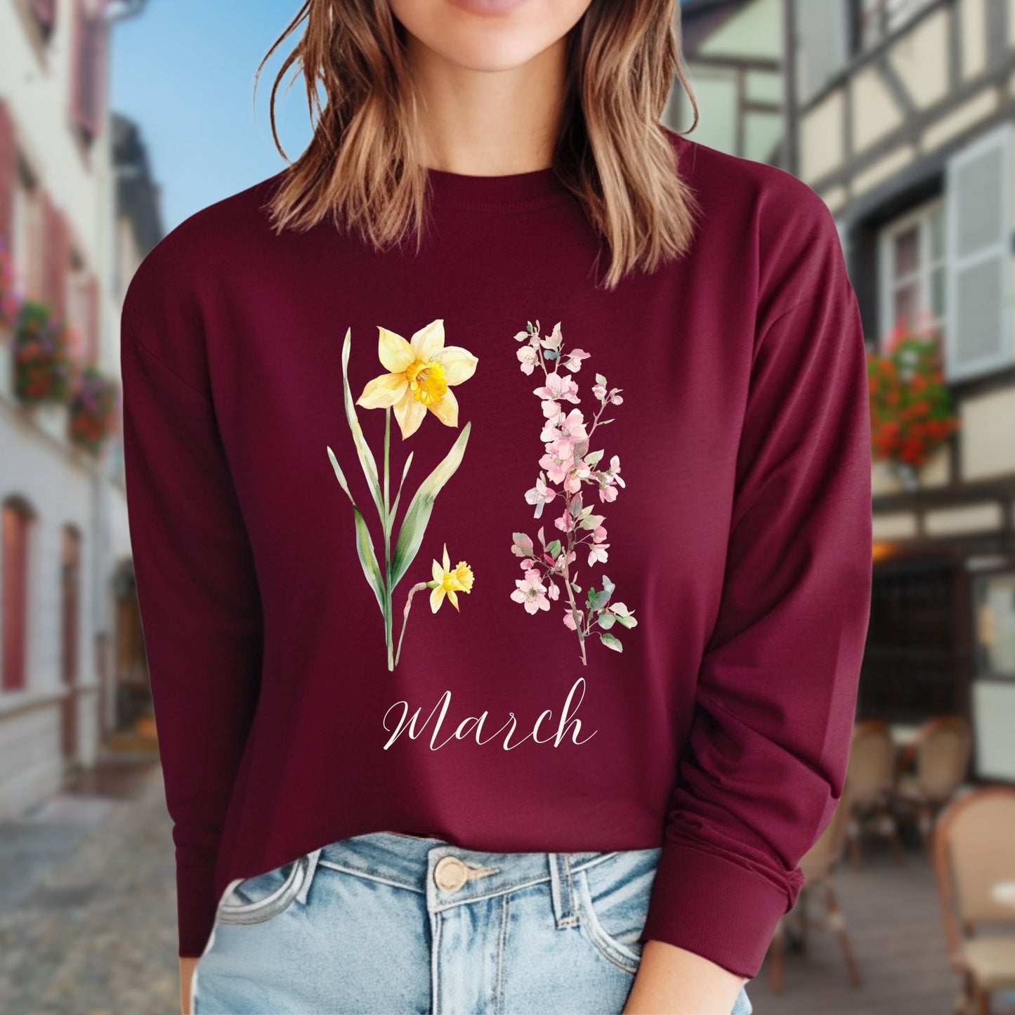 Maroon long-sleeve tee with hand-drawn daffodil, pink cherry blossoms, and "March" script.