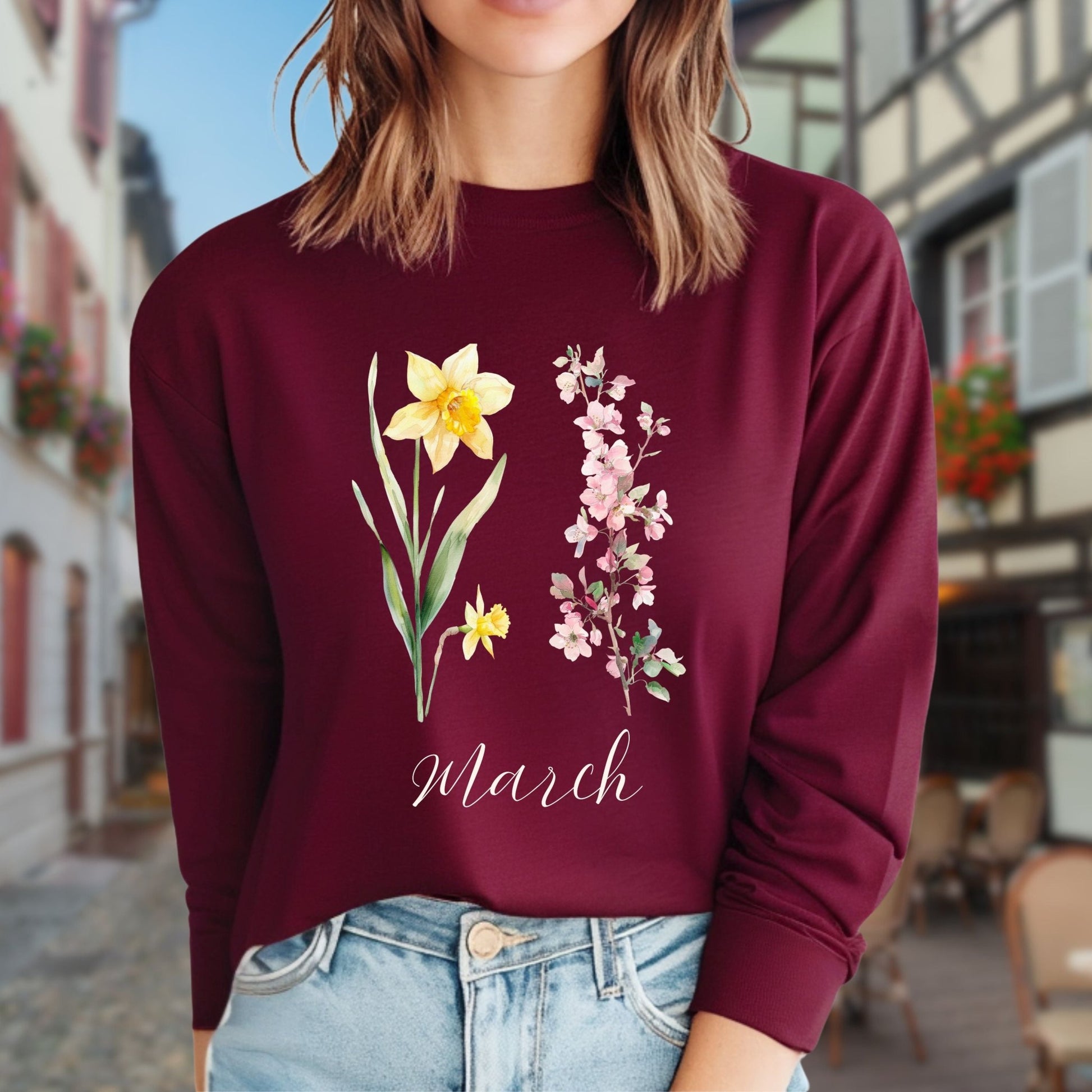 Maroon long-sleeve tee with hand-drawn daffodil, pink cherry blossoms, and "March" script.