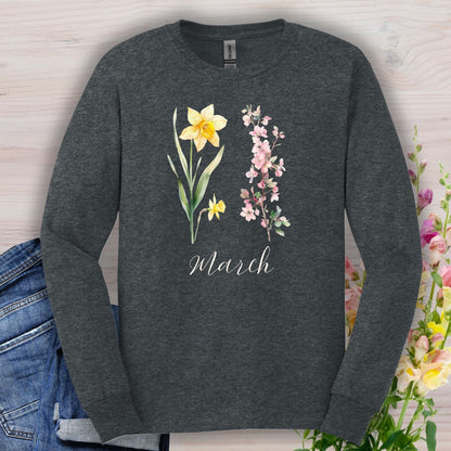 Dark heather long sleeve tee with hand-drawn daffodil, pink cherry blossoms, and "March" script.