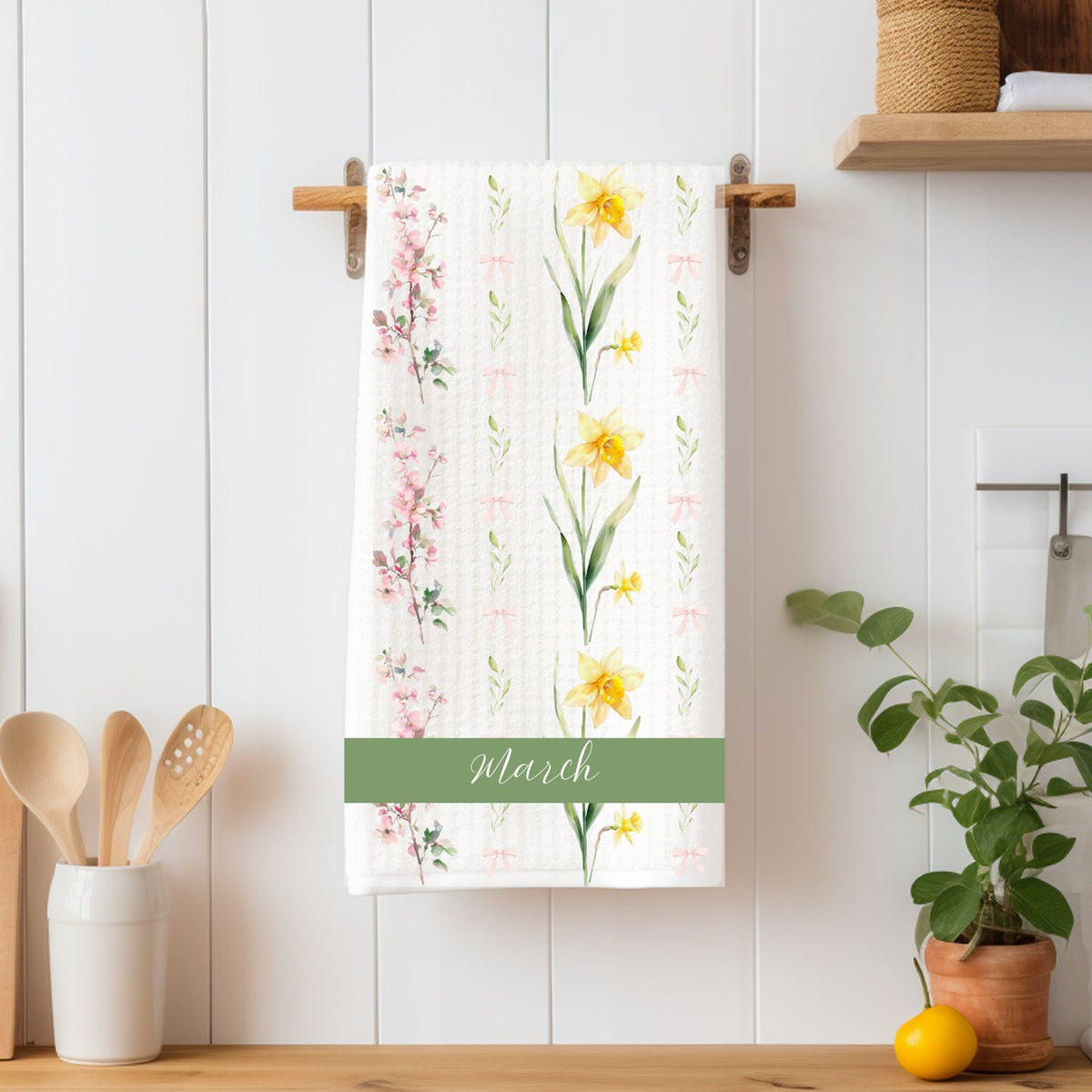 White tea towel with daffodil and cherry blossom floral design, "March" in green script.