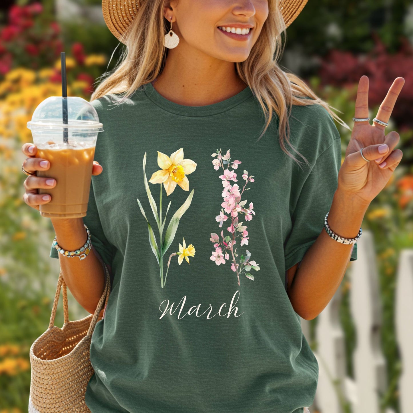 Garment-dyed green t-shirt with watercolor daffodils, cherry blossoms, and "March" script.