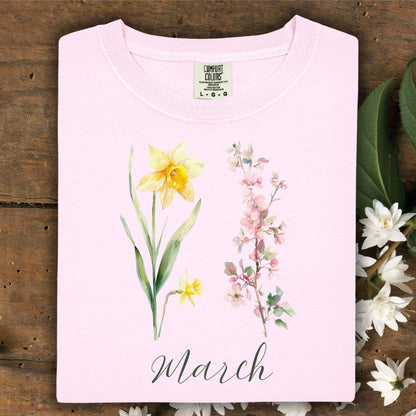 Blossom pink garment-dyed t-shirt with watercolor daffodil, cherry blossoms, and "March" script.