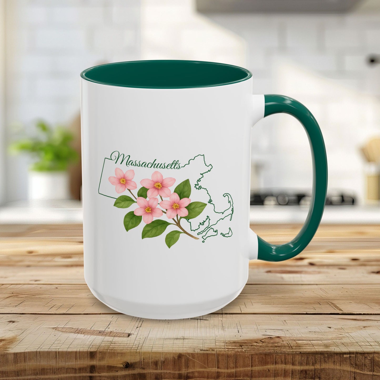 White 15oz ceramic mug with a green handle and interior, featuring a Massachusetts state outline and Mayflower design.