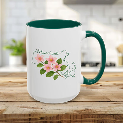 White 15oz ceramic mug with a green handle and interior, featuring a Massachusetts state outline and Mayflower design.