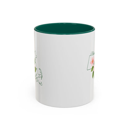 White ceramic mug with a green interior and handle, featuring a Massachusetts state outline and Mayflower design.