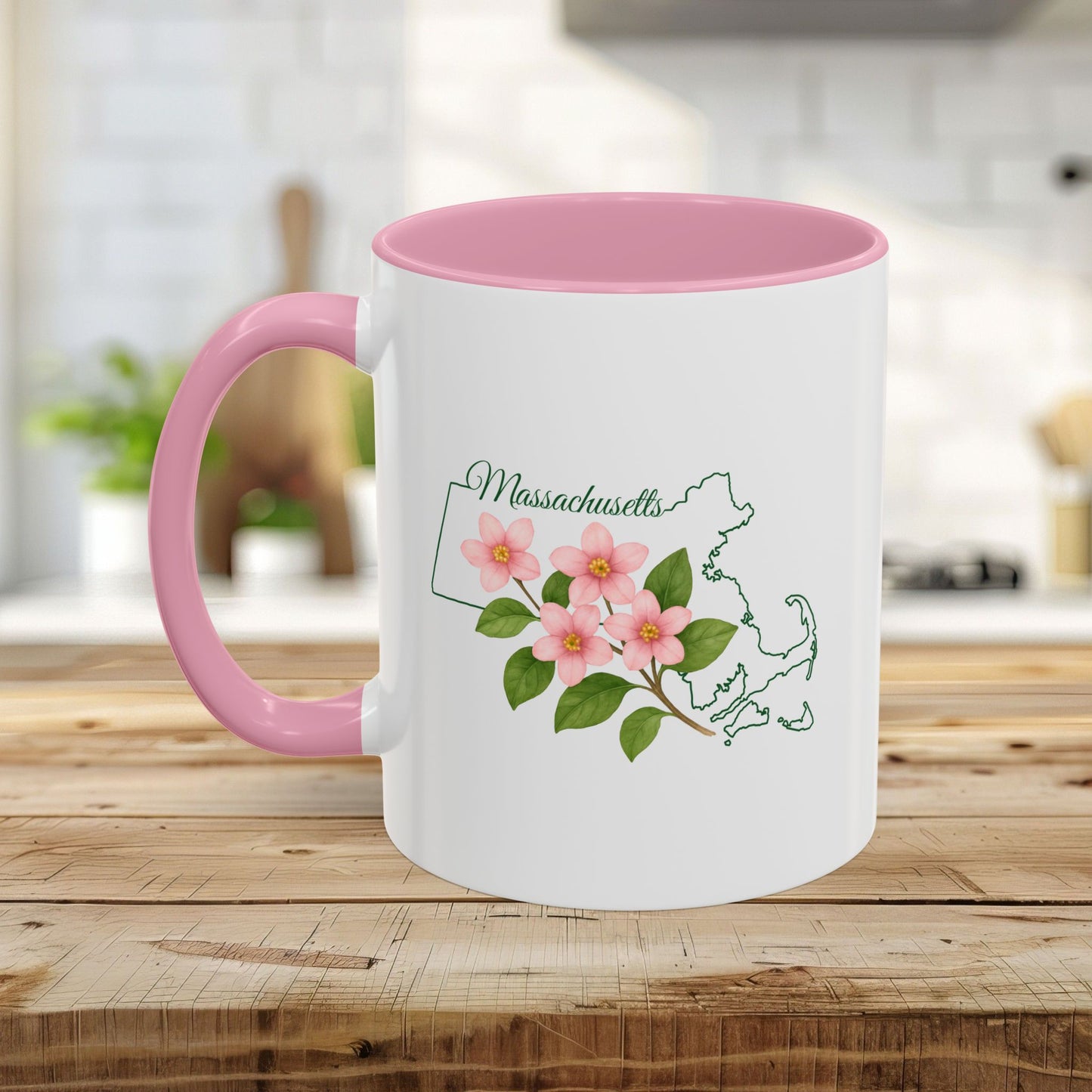 White ceramic mug with pink interior and handle, featuring a Massachusetts state outline and Mayflower illustration.