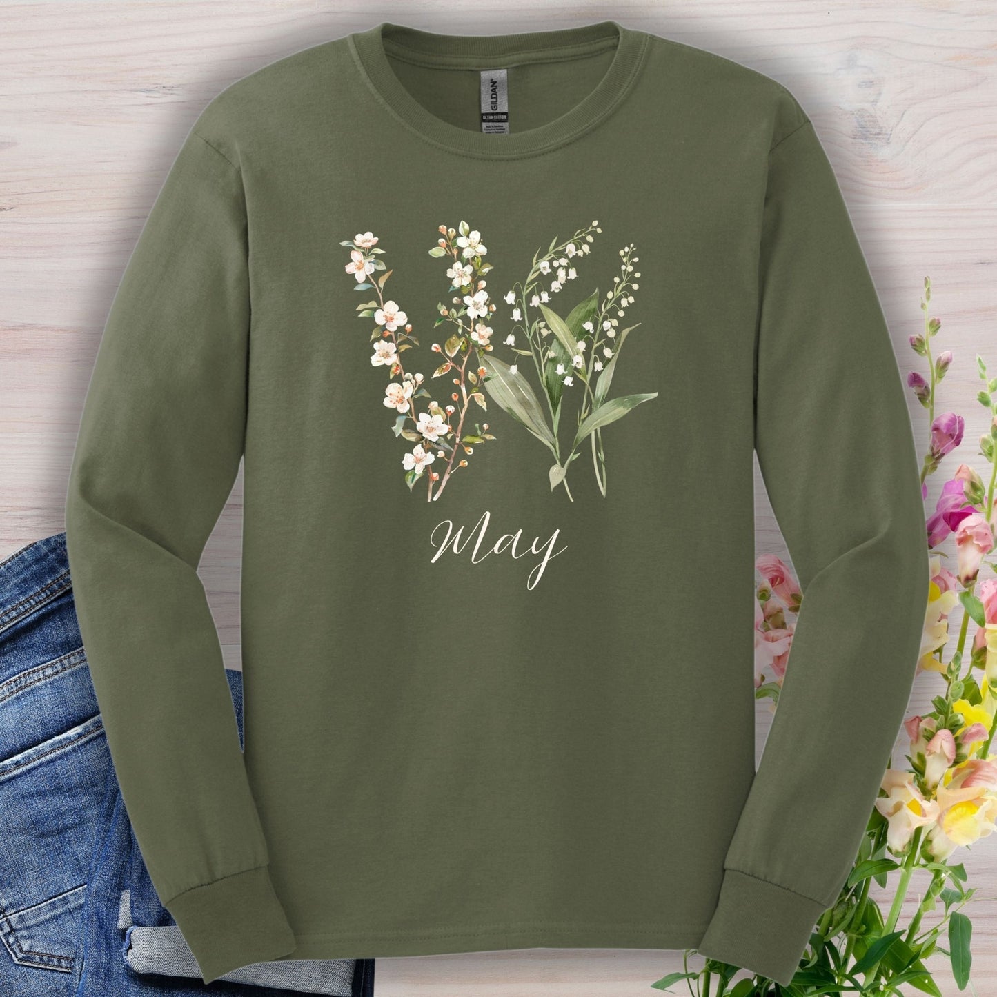 Olive green long sleeve tee with watercolor lily of the valley and hawthorn blossoms, "May" script.