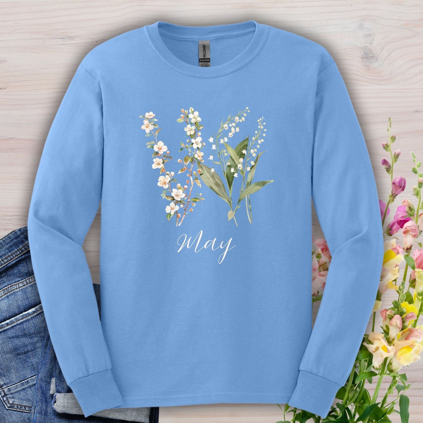 Carolina Blue long-sleeve tee with watercolor lily of the valley, hawthorn blossoms, and "May" script.