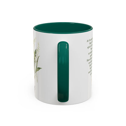 White ceramic mug with a dark green handle and interior, featuring a delicate May birth month flower design.