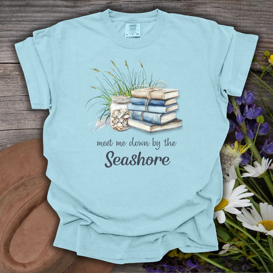Chambray blue, relaxed-fit S t-shirt with "Meet Me Down By the Seashore" text and beach vignette.