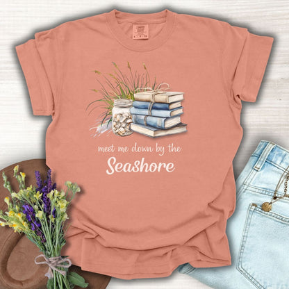 Terracotta garment-dyed t-shirt with "Meet Me Down By the Seashore" text and beach book graphic.