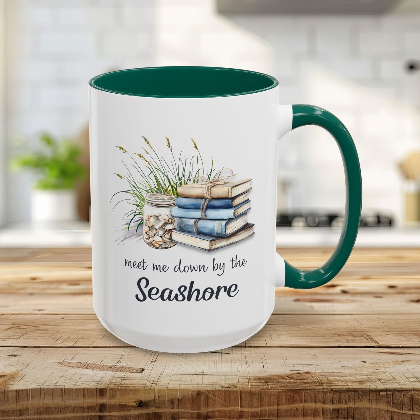 White 15oz ceramic mug with green handle/interior, featuring watercolor stacked books, beach grasses, shells, and "meet me down by the Seashore.