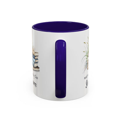 White ceramic mug with purple interior and handle, featuring watercolor art of stacked books and beach grasses.