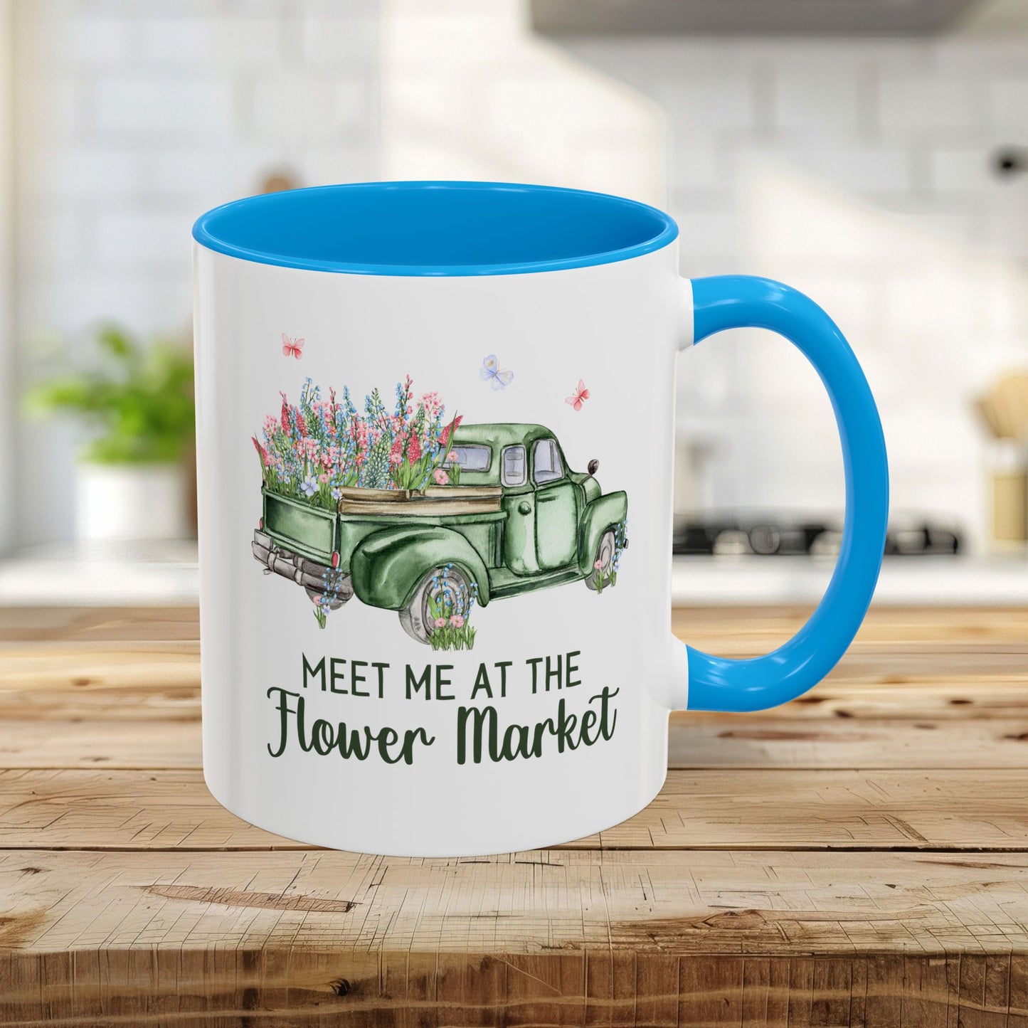 White ceramic 11oz mug with light blue interior/handle, featuring a vintage green pickup truck overflowing with flowers.