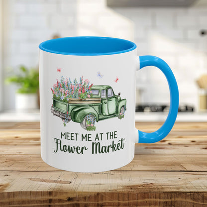 White ceramic 11oz mug with light blue interior/handle, featuring a vintage green pickup truck overflowing with flowers.