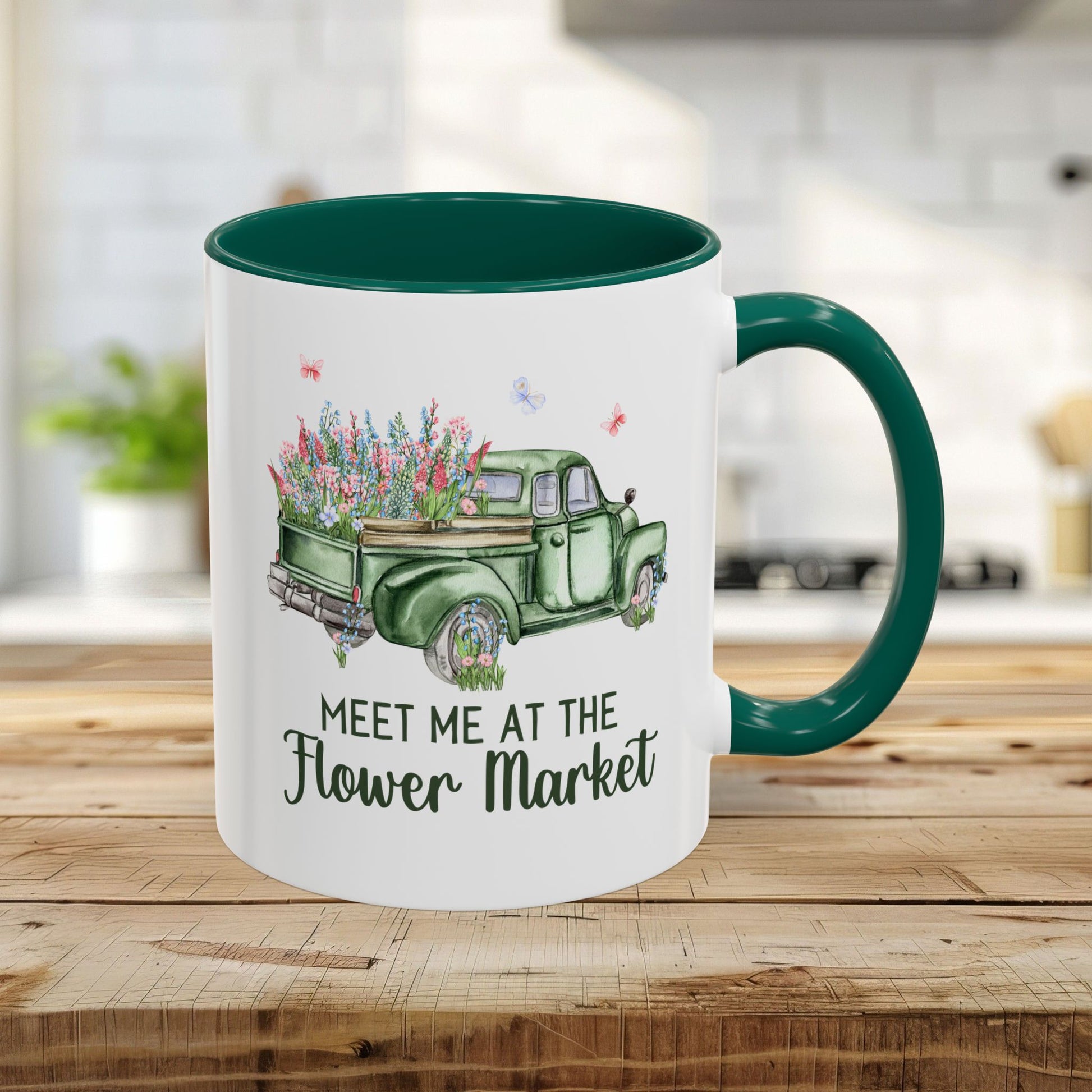 White ceramic mug with green interior and handle, featuring a vintage green pickup truck overflowing with colorful flowers and "Meet Me at the Flower Market" text.