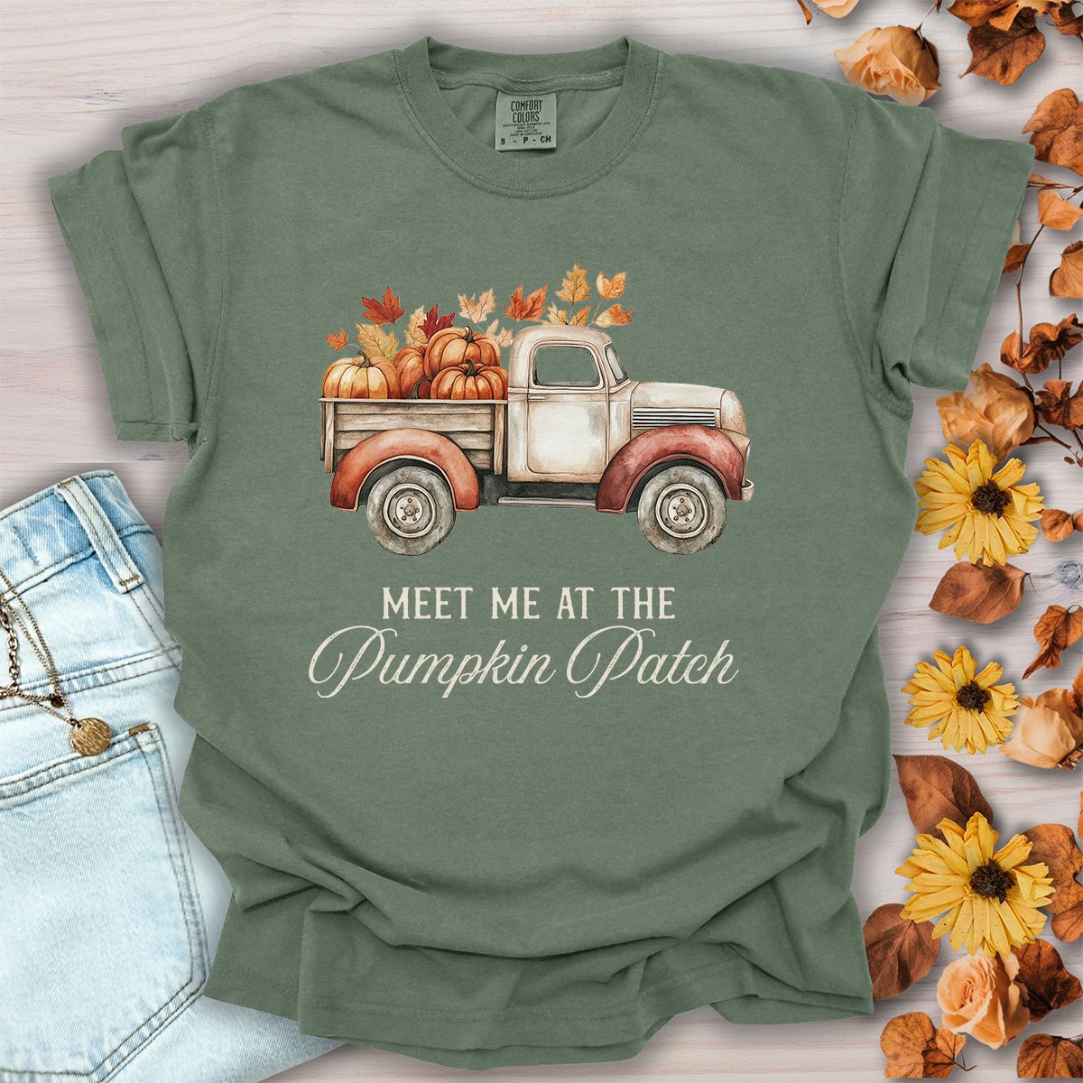 Moss green, garment-dyed cotton t-shirt featuring a watercolor vintage truck filled with pumpkins and autumn leaves.