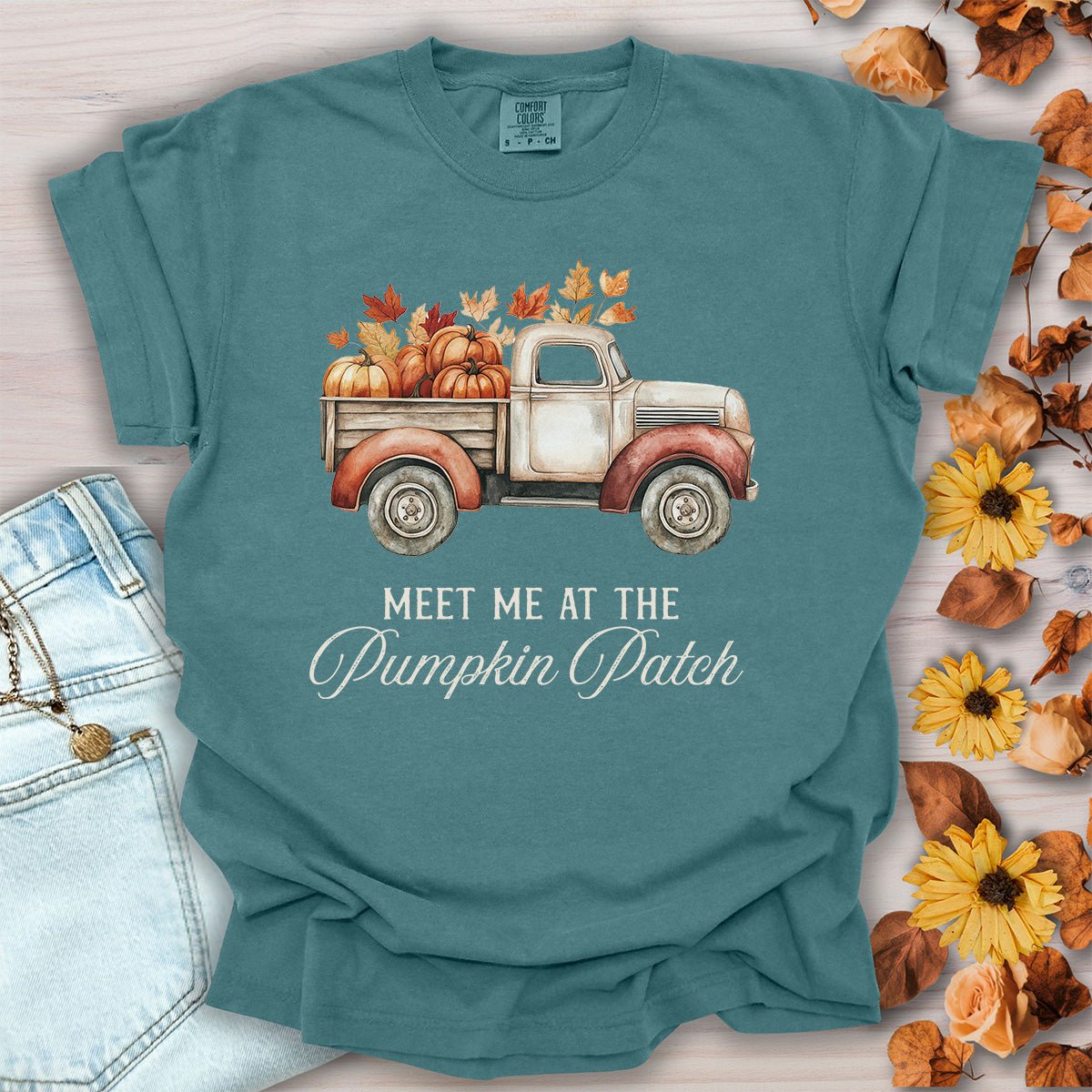 Blue spruce garment-dyed cotton t-shirt featuring a watercolor vintage truck with pumpkins and autumn leaves.
