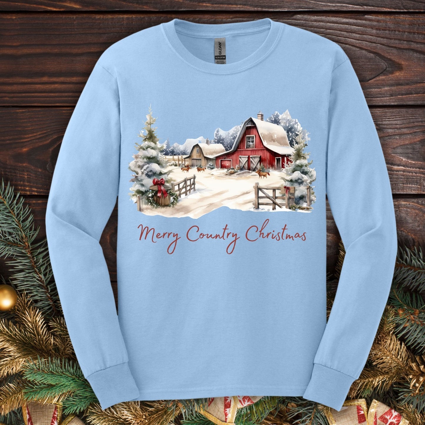 Light blue Gildan long sleeve tee with a snowy red barn and "Merry Country Christmas" text.