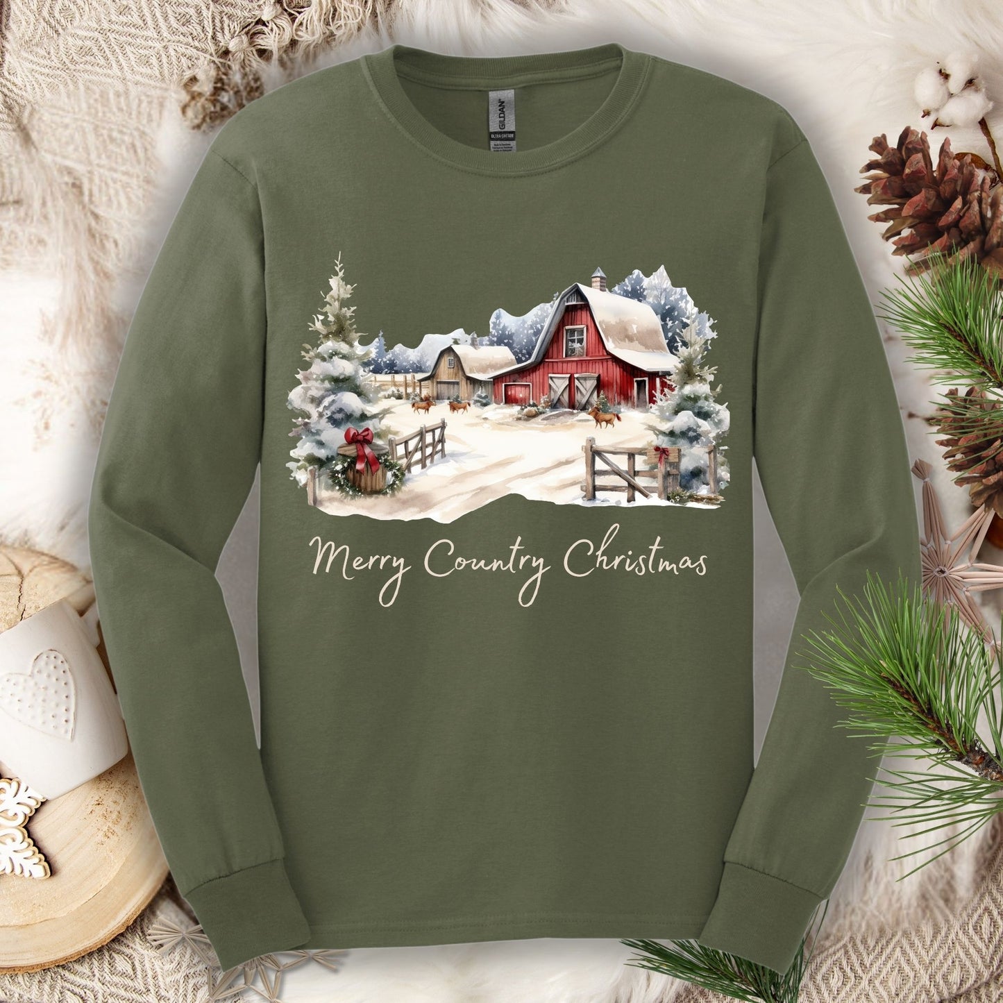 Military Green long sleeve tee with a snowy red barn, pine trees, and "Merry Country Christmas" text.