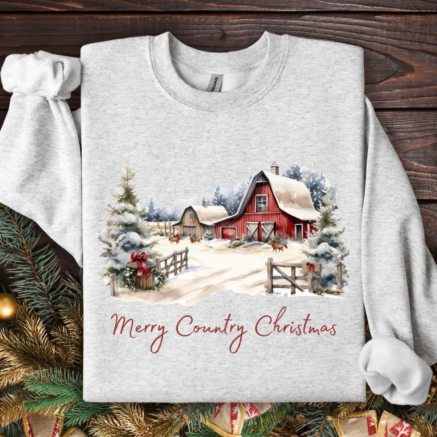 Ash Gildan sweatshirt with a watercolor red barn, snowy trees, and "Merry Country Christmas" text.